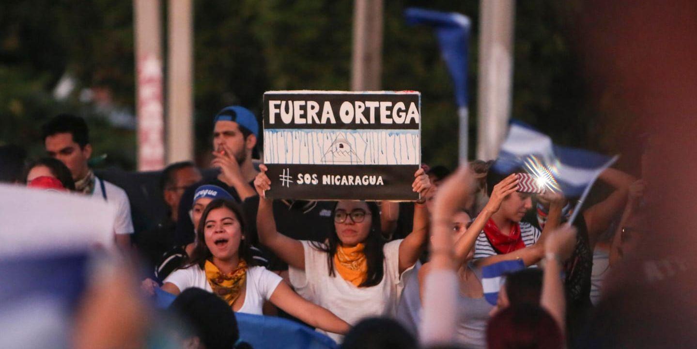 En kvinna håller upp en skylt med texten "Avgå Ortega" under protester i söndags mot president Daniel Ortegas regering i Nicaraguas huvudstad Managua.
