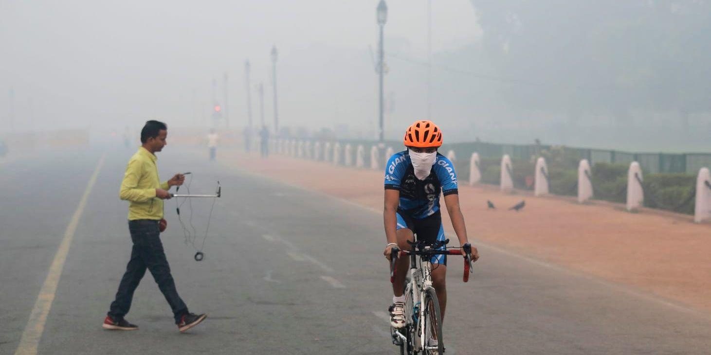 En cyklist med andningsmask på väg till jobbet i Delhi på fredagsmorgonen.