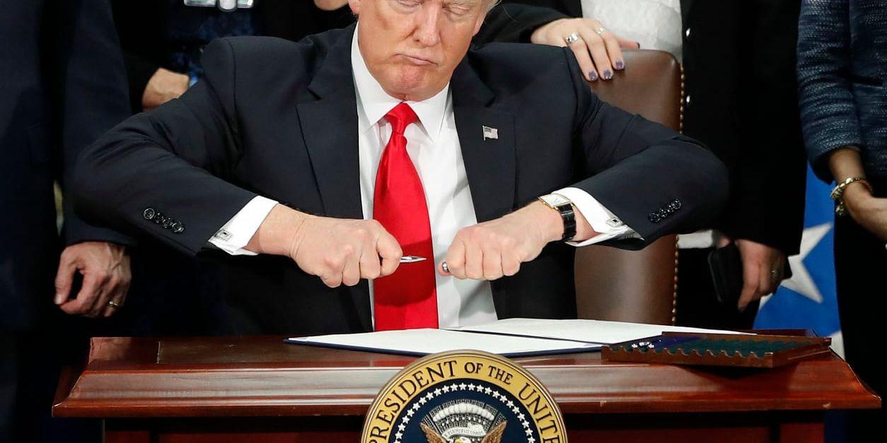 USA:s president Donald Trump gör sig redo att skriva under sitt första inreseförbud, i januari i fjol.