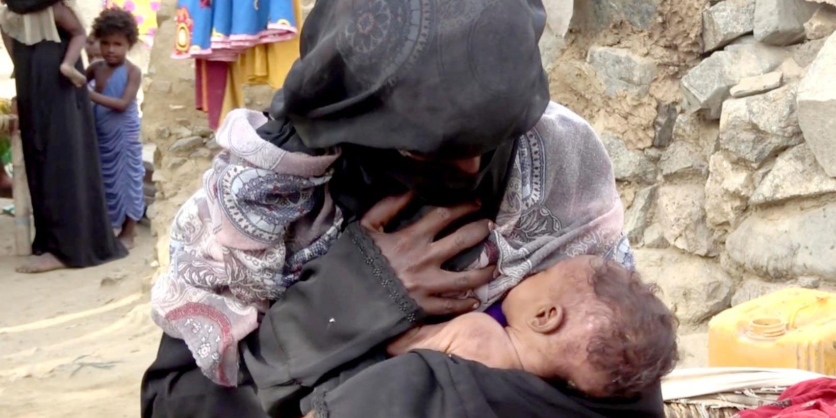 En kvinna ammar sitt undernärda barn i Jemen. Arkivbild.