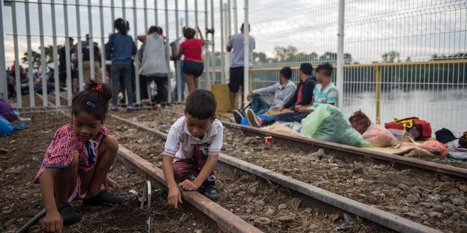 Två barn från Honduras leker vid tågspåren invid gränsen mellan Guatemala och Mexiko, i Ciudad Hidalgo, på lördagen.