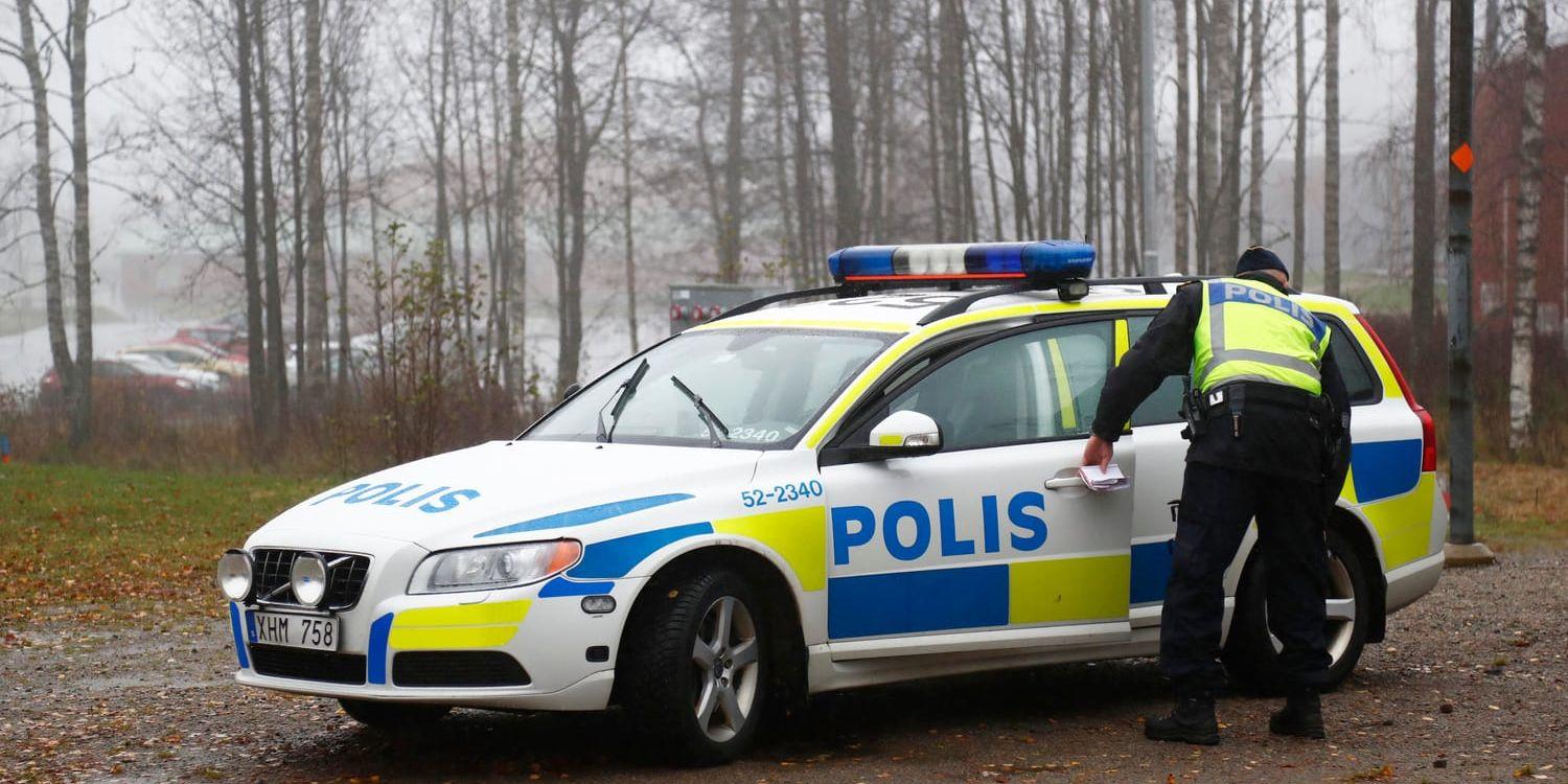 En polis vid området i Ulricehamn där en kvinna hittades död i oktober. Arkivbild.