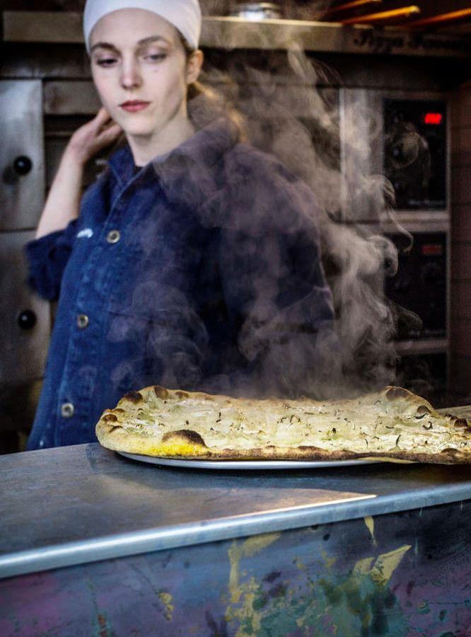 För att få rätt styvhet på pizzaslicen bakar Emma Kolback ut pizza i majsmjöl, som bildar en tunna skorpa på den degen. Bild: Maja Kristin Nylander