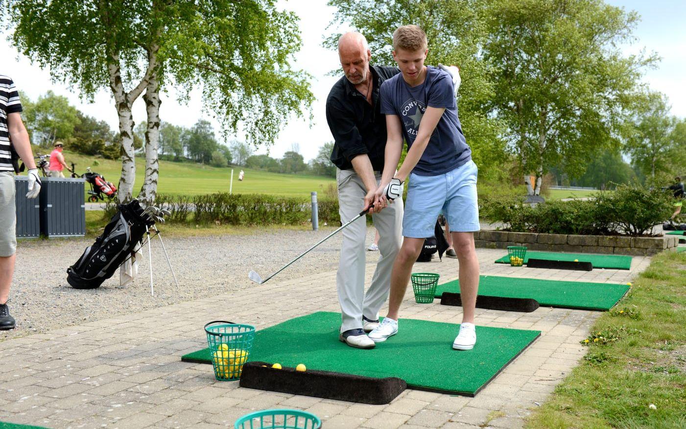Gör såhär. Kai Nilsson instruerar nybörjaren Arvid Stark från Viskafors om hur golfspel ska gå till.