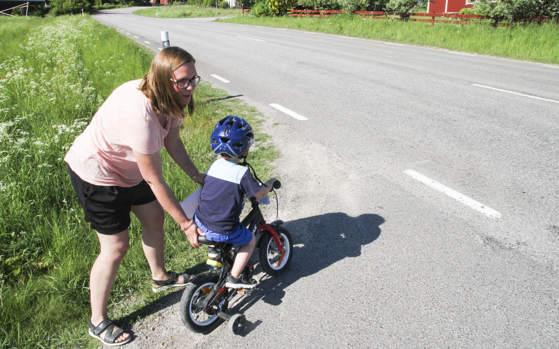 Lina Buurstra hjälper sonen Eskil över vägen. Drygt 2 000 fordon kör dagligen på väg 845.