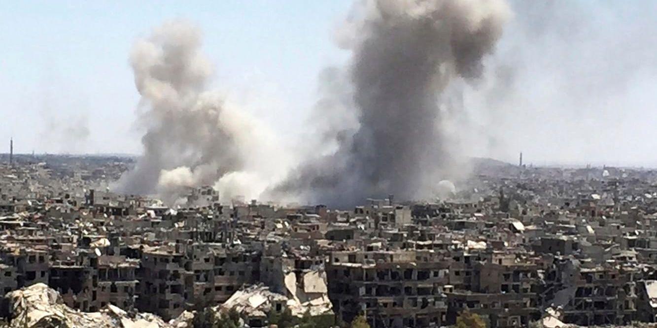 Rök stiger från området Hajar al-Aswad, i södra Damaskus, efter regimens flyganfall under tisdagen.
