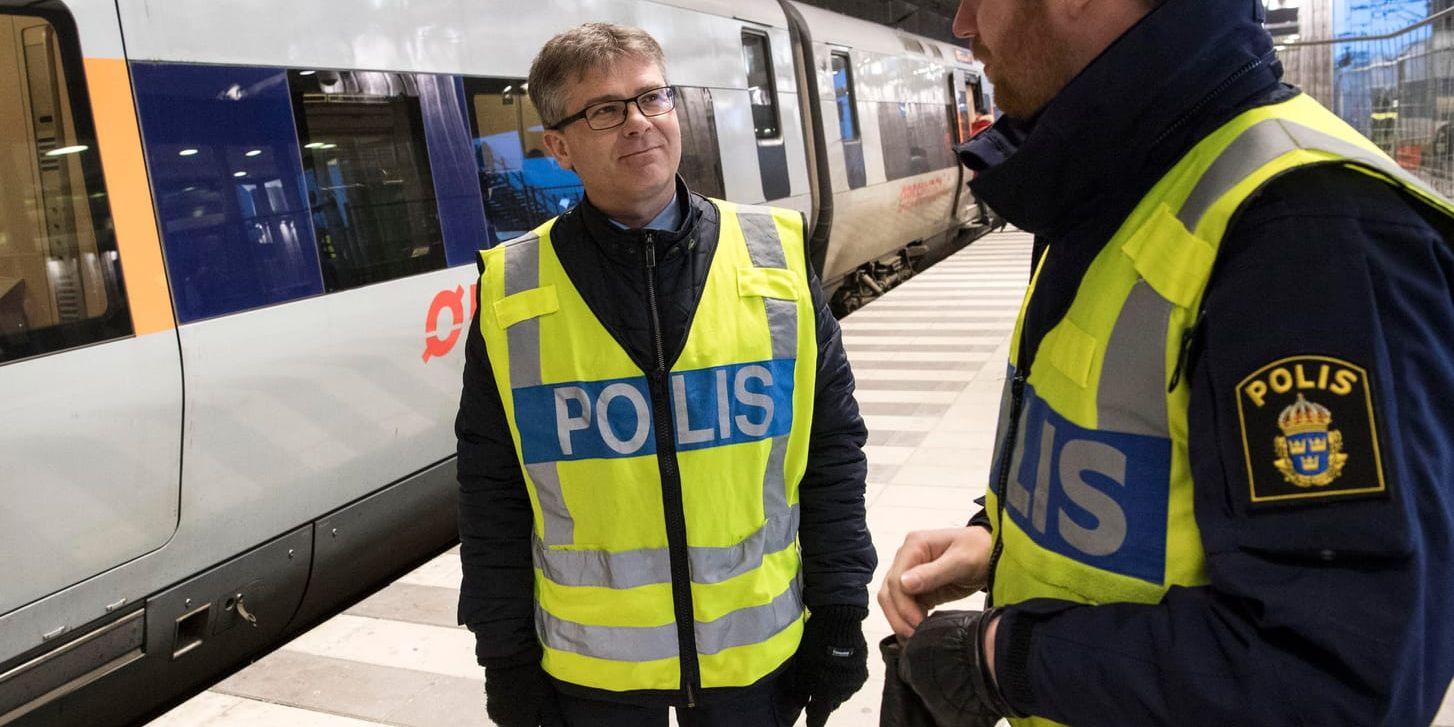 Michael Mattsson, chef för gränspolisen i region Syd, pratar med polisen Simon Svensson framför ett Öresundståg på station Hyllie utanför Malmö.