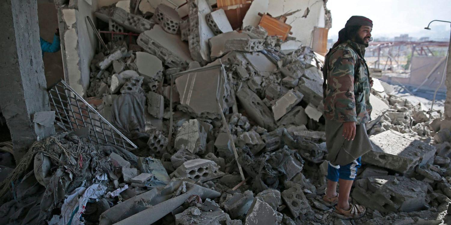 En man betraktar förödelsen i den bombade byggnad som användes som fängelse av Huthi-milisen.