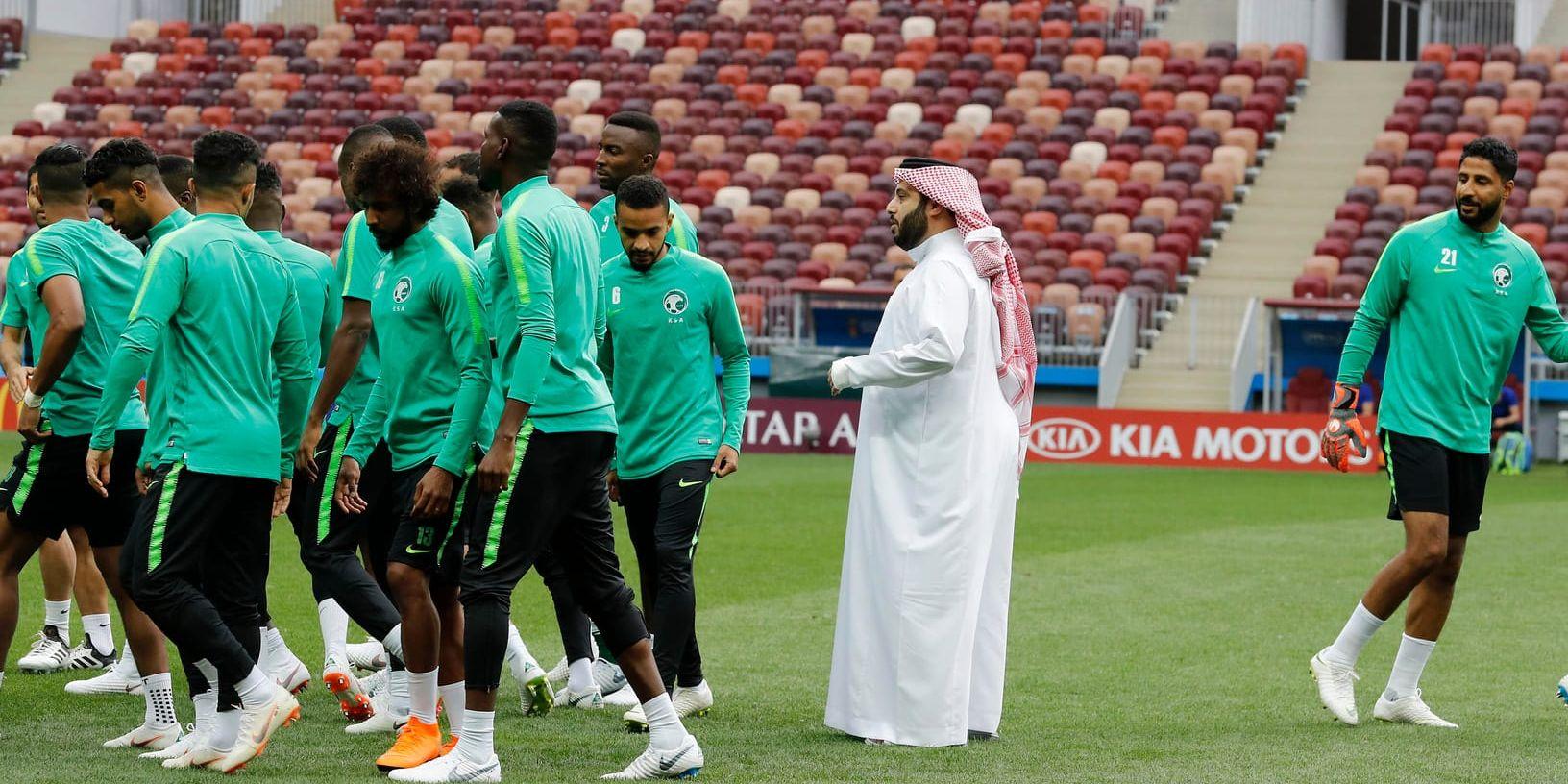 Saudiarabiens landslag tvingas nöja sig med ryska fanbärare i eftermiddagens VM-premiär mot Ryssland. Här talar landets idrottsminister Turki al-Sheikh med dem inför onsdagens träning.