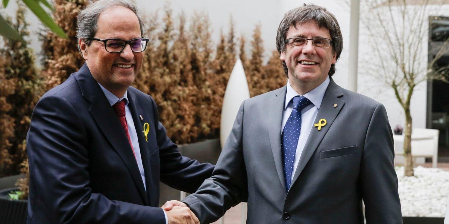 Kataloniens regionpresident Quim Torra (t v) skakar hand med sin föregångare Carles Puigdemont, som avvaktar en utlämningsdom i Tyskland och som anses dra i trådarna i regeringsbildandet på hemmaplan. Arkivbild.