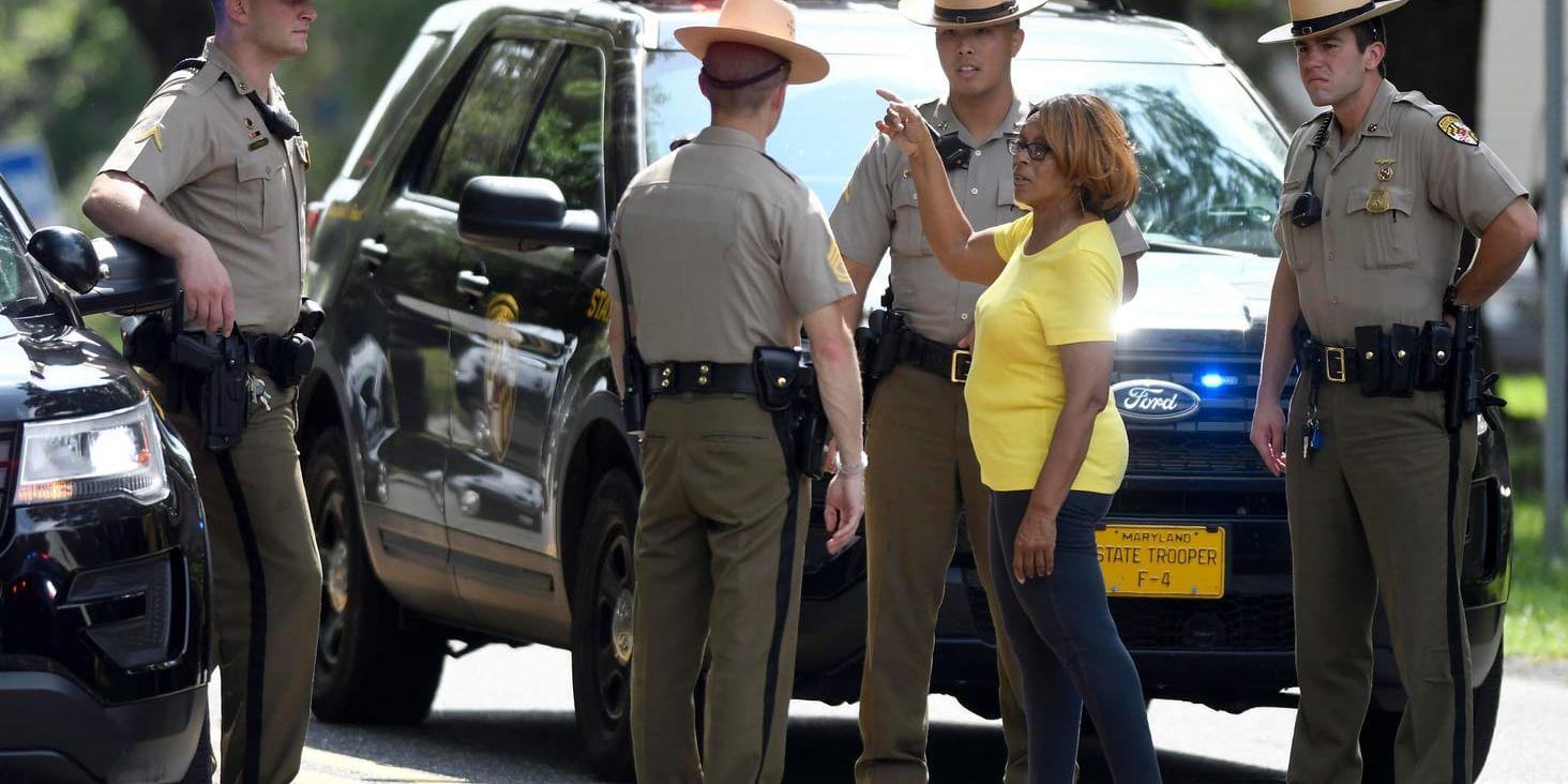 En privatperson talar med poliser som samlats i närheten av platsen för skottlossningen i Maryland.