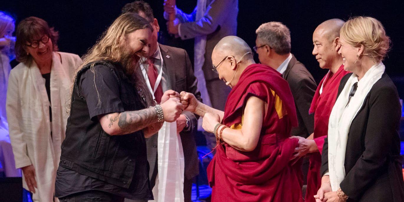 Dalai lama är på gott humör under Malmöbesöket och passar på att skuggboxas med operasångaren Rickard Söderberg när han får chansen. Genom att le, skoja och sprida värme till andra människor blir du själv lycklig, är hans budskap.