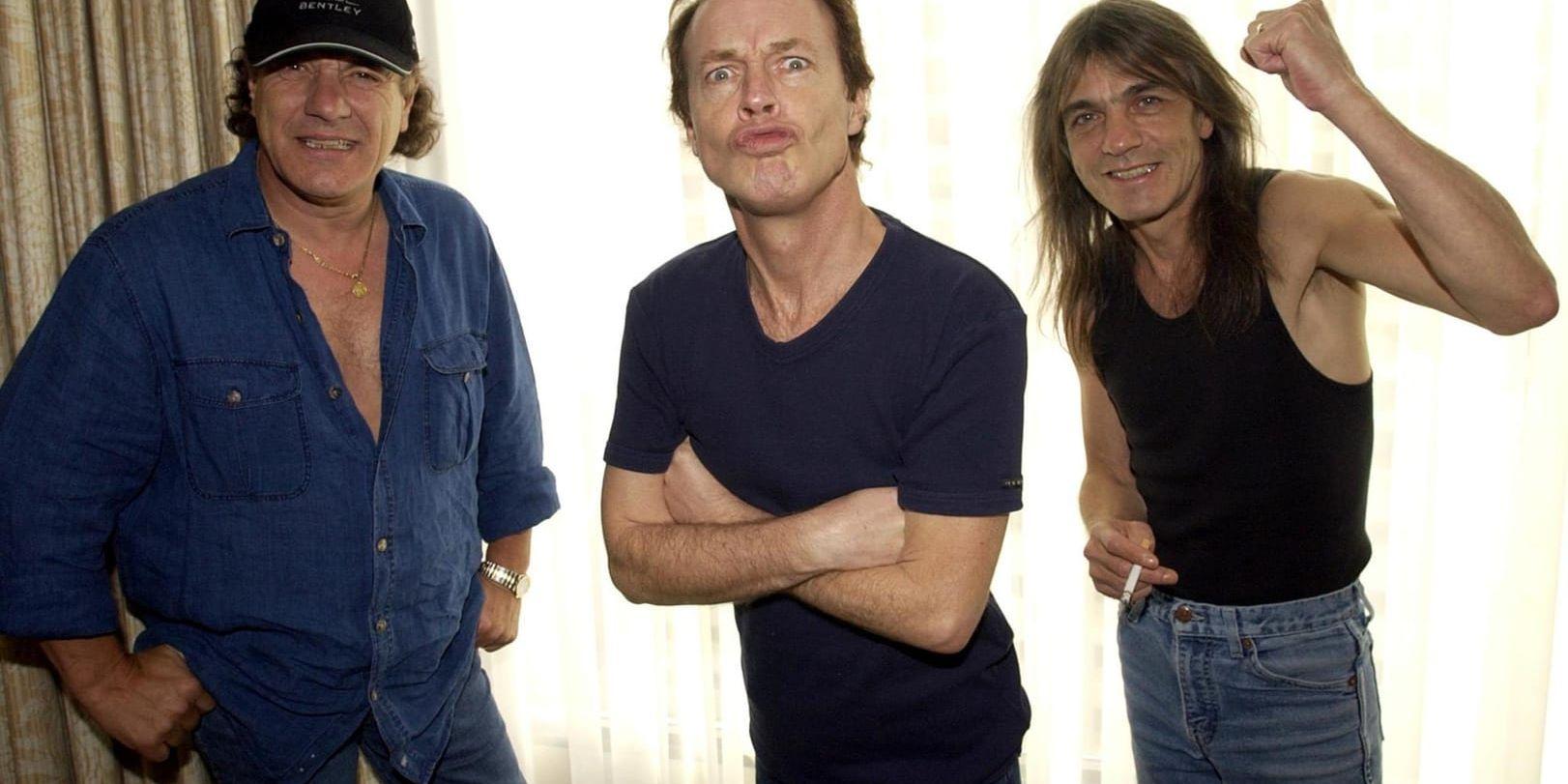 Brian Johnson, Angus Young och Malcolm Young i AC/DC vid en fotografering 2003. Malcolm Young blev 64. Arkivbild.