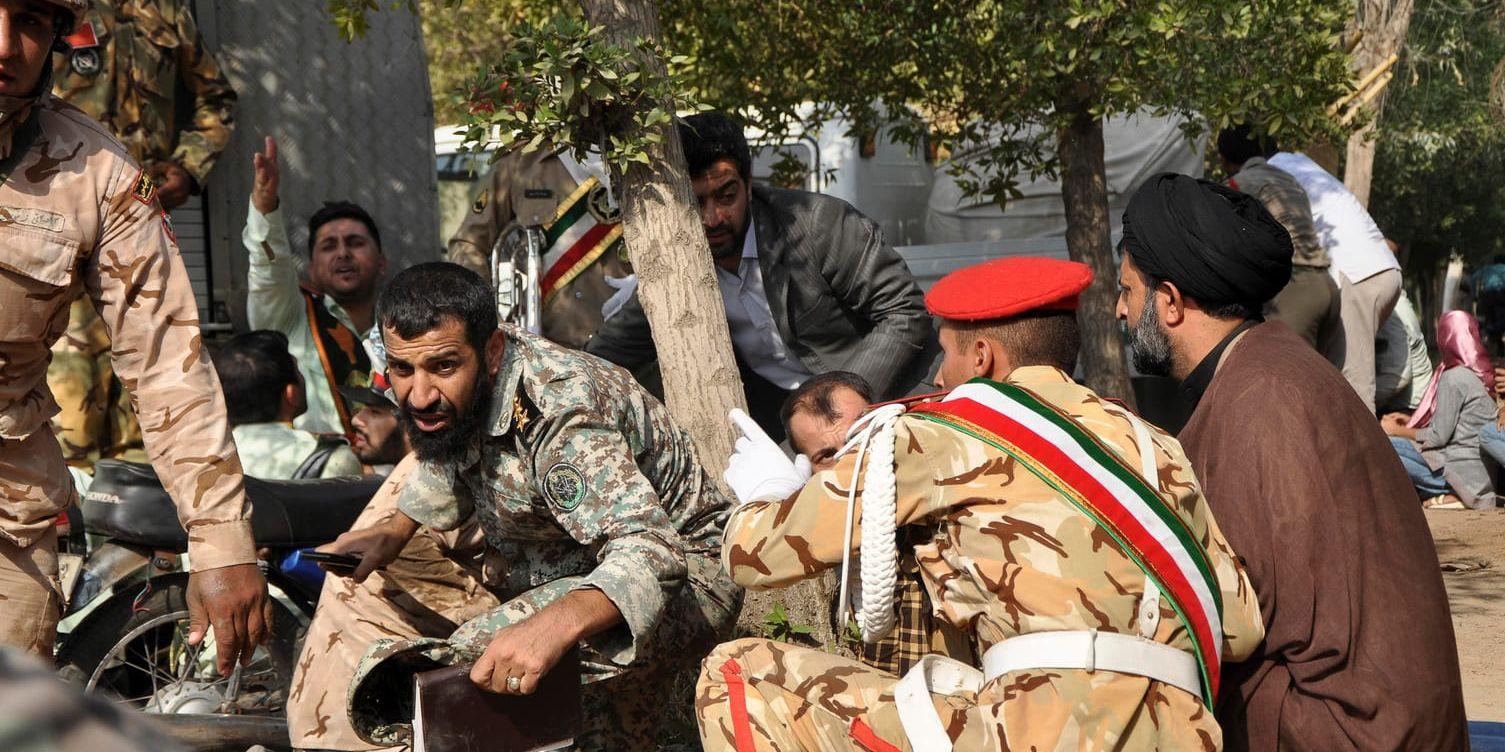 Iranska soldater och civila tar skydd under attacken mot militärparaden i Ahvaz.