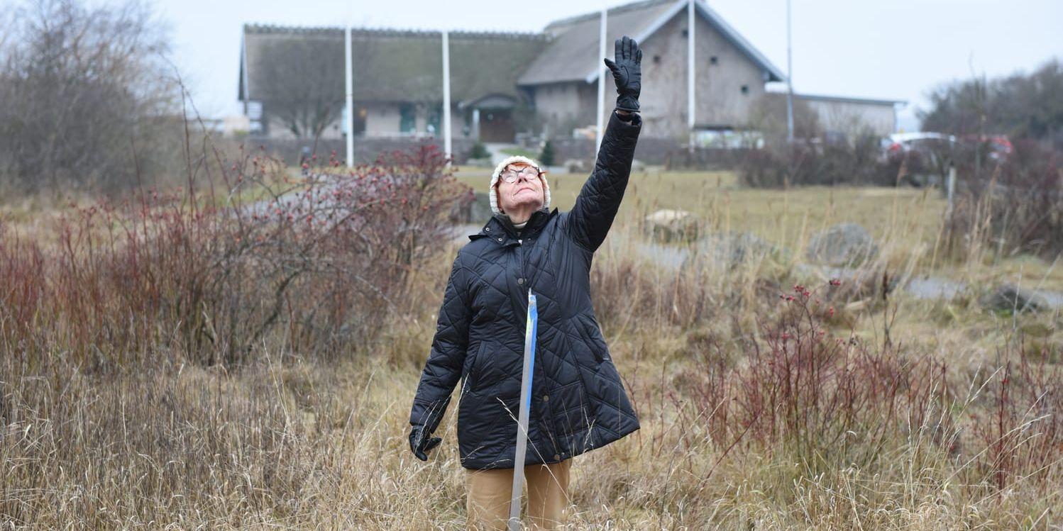 Inger Wennerlund pekar mot skyn för att gestalta den planerade vallens höjd, vallen kommer gå rakt över naturums område.