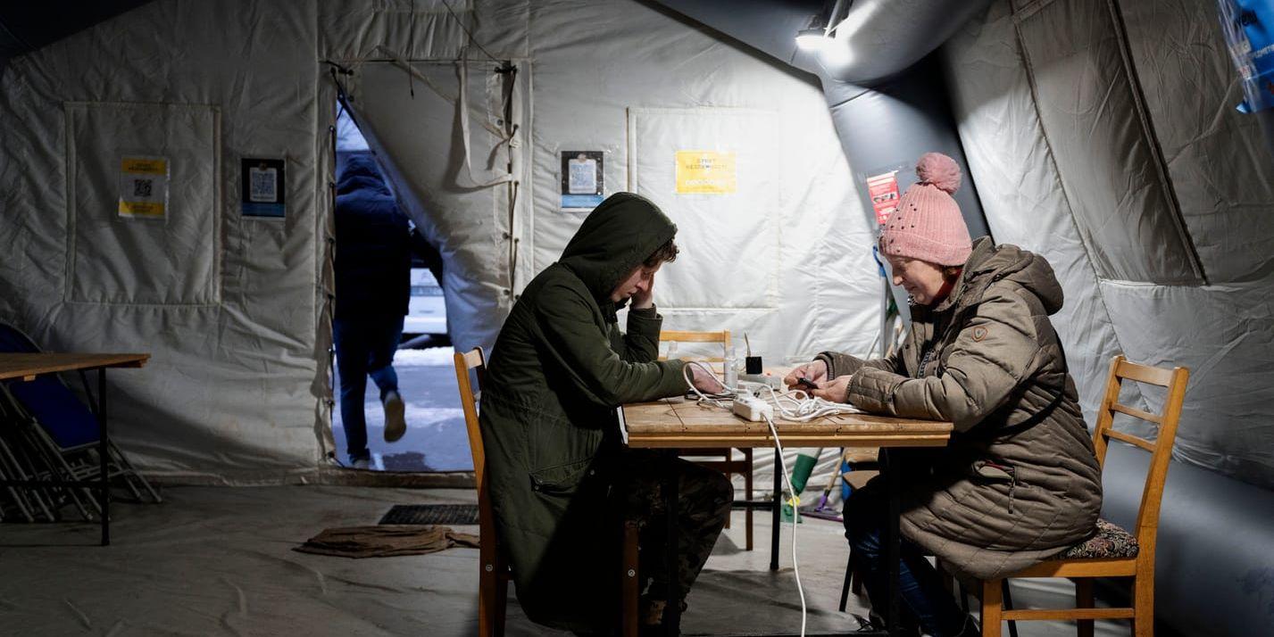 Hjälpbehoven ökar med kölden och bristen på vatten och el. Då lindrar de tusentals värmetält som satts upp över hela Ukraina. Ludmila, 47, laddar sin mobiltelefon och värmer sig i ett värmetält i samhället Irpin utanför Kiev.