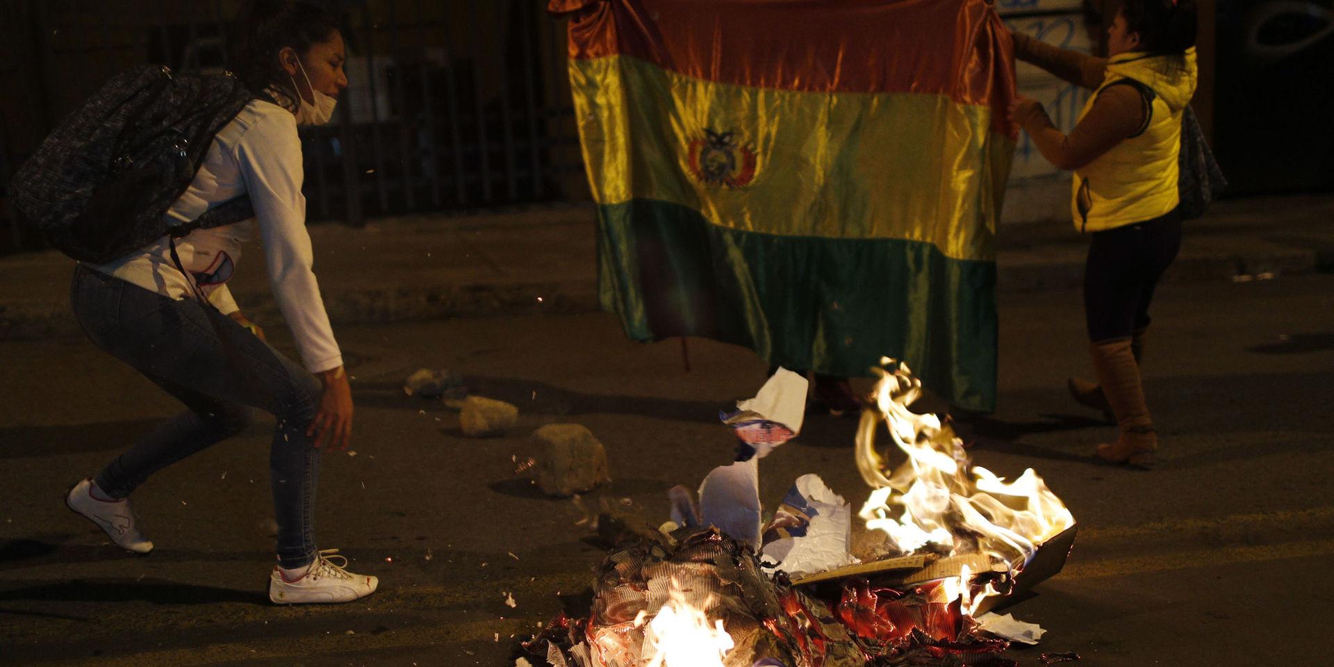 Demonstranter bränner valaffischer utanför valmyndigheten i protest mot resultatet.