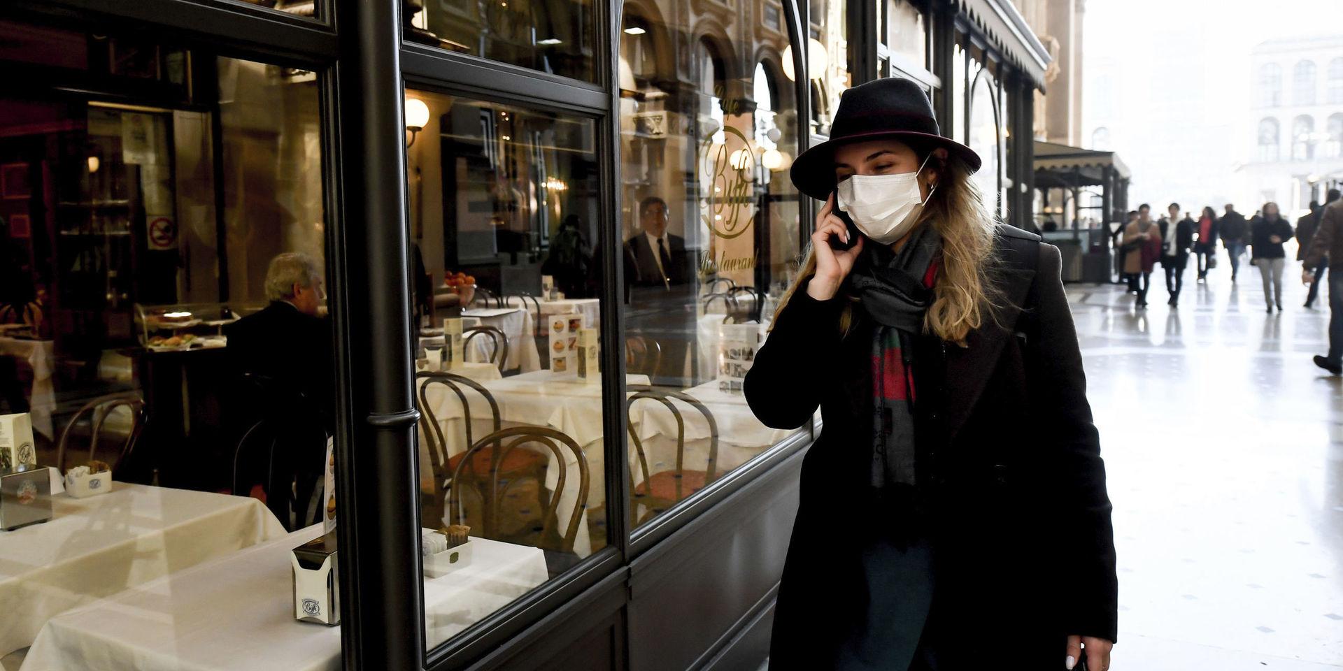 A woman wearing a sanitary mask talks on the phone in downtown Milan, Italy, Monday, Feb. 24, 2020. At least 190 people in Italy’s north have tested positive for the COVID-19 virus and four people have died, including an 84-year-old man who died overnight in Bergamo, the Lombardy regional government reported. (Claudio Furlan/Lapresse via AP)  MIL806