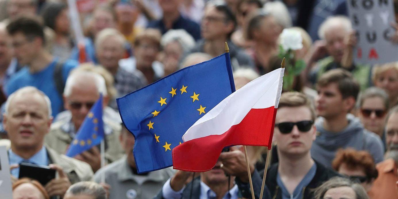 Polens flagga och EU-flaggan vajar tillsammans vid en demonstration i Warszawa. Arkivfoto.