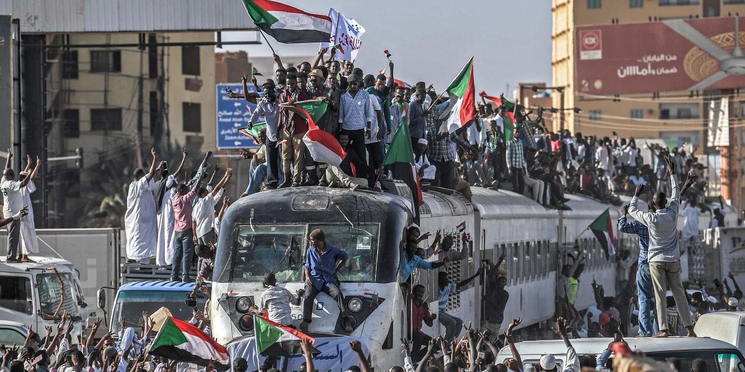 Demonstranter som kommer med tåg till Sudans huvudstad Khartum tas emot av jublande likasinnade.