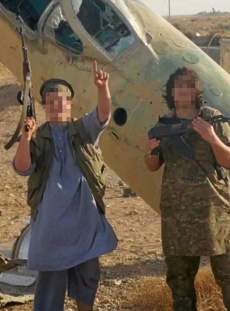Äldste sonen, som gått i skola i Halmstad, poserar vid ett nedskjutet MiG-plan i Syrien. Han dog som IS-krigare när han var 18 år.