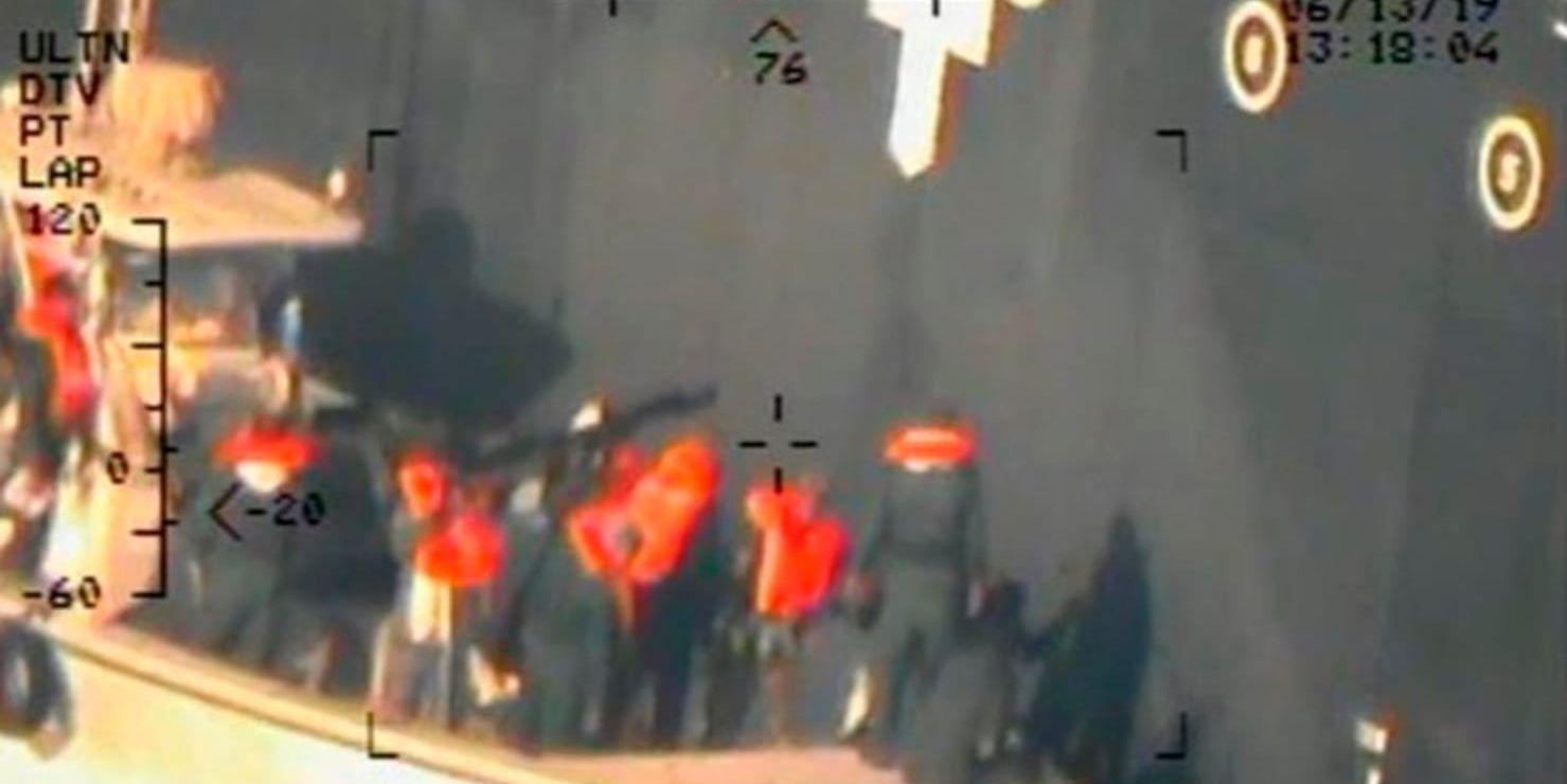 Enligt USA är detta iranska revolutionsgardister som försöker ta bort en odetonerad mina från det japanska fartyget som attackerades. Bilden har tillhandahållits av USA:s försvarsdepartement.