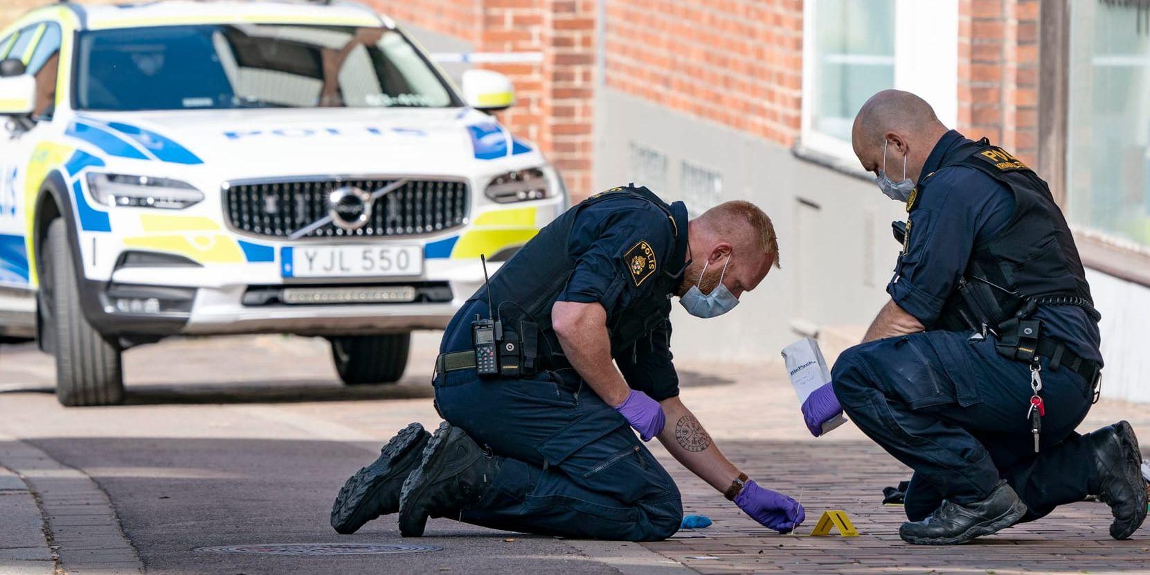 Polisens kriminaltekniker i arbete på den trottoar i centrala Helsingborg där en kvinna utsattes för ett knivdåd.