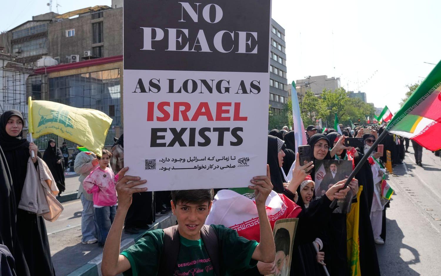 ”Ingen fred så länge Israel existerar”. En pojke med en skylt vid en statligt organiserad demonstration i Teheran på fredagen.