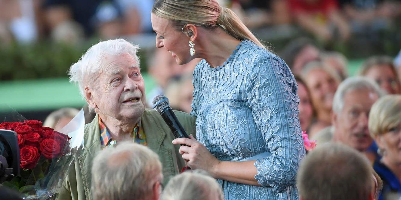 Lasse Lönndahl, som fyller 90 år, fick en bukett rosor av Sanna Nielsen och bjöds in att sjunga några rader ur Vikingarnas låt "Tiotusen röda rosor".