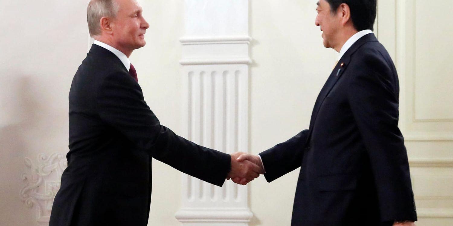 Rysslands president Vladimir Putin och Japans premiärminister Shinzo Abe skakar hand i Moskva på lördagen.