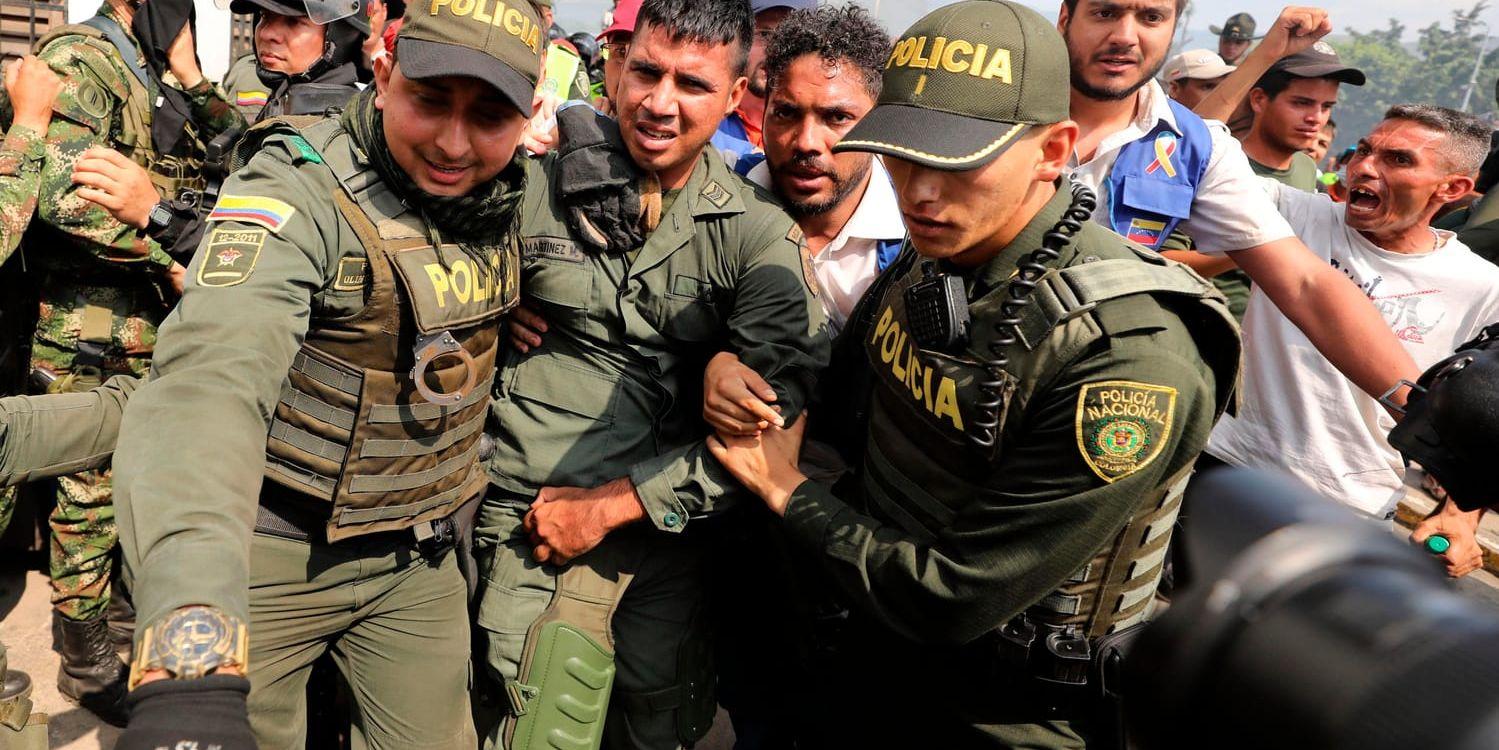 En avhoppad venezuelansk soldat blir eskorterad av colombianska poliser efter att ha passerat gränsen över till grannlandet.