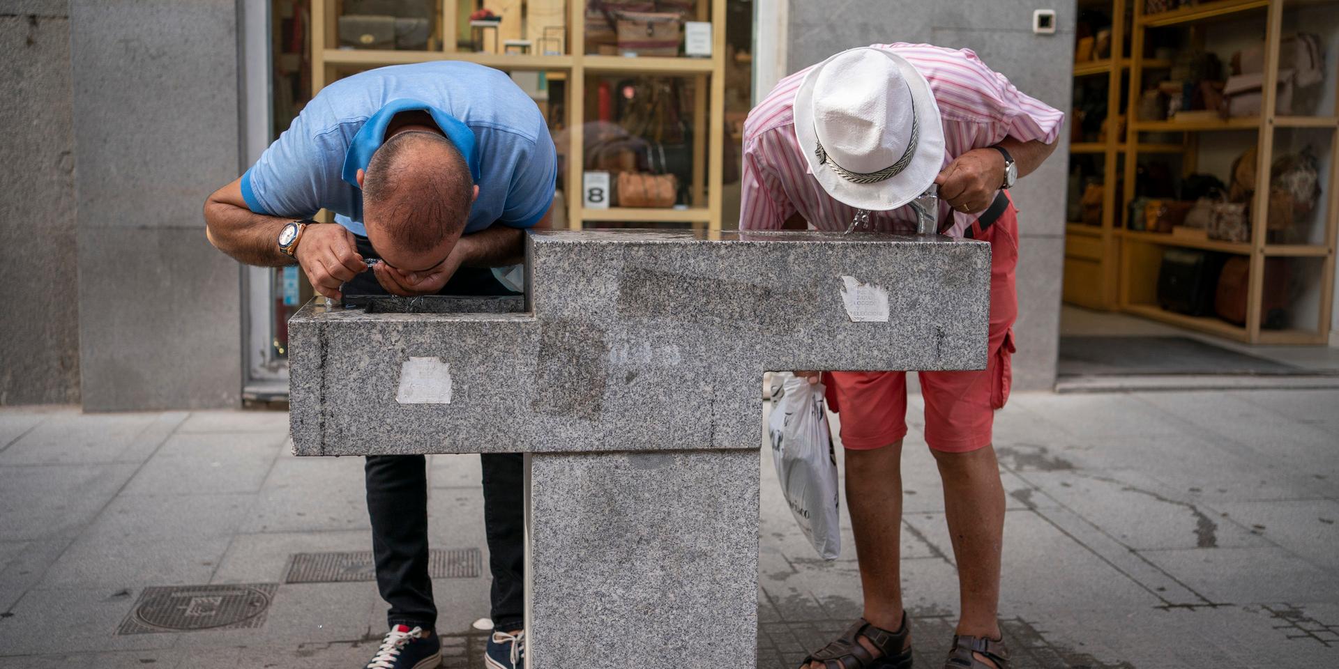 Två män svalkar sig under förra sensommarens värmebölja i Spanien. Arkivbild.