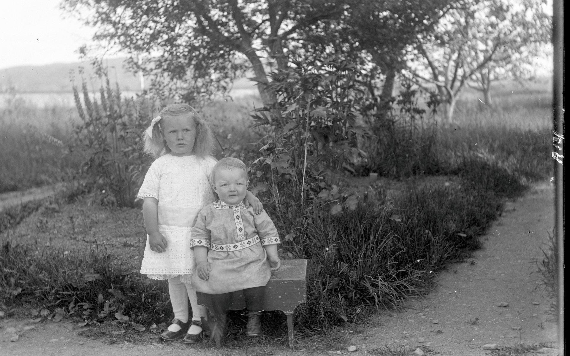 Två barn har ställt upp sig för fotografering för bygdens mångsidiga man Gunnar Engström.