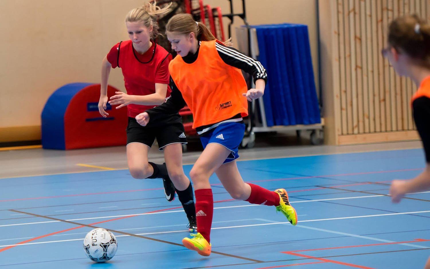 Ebba Davidsson (röd väst) och Wilma Freytag (orange väst) i kamp om bollen.