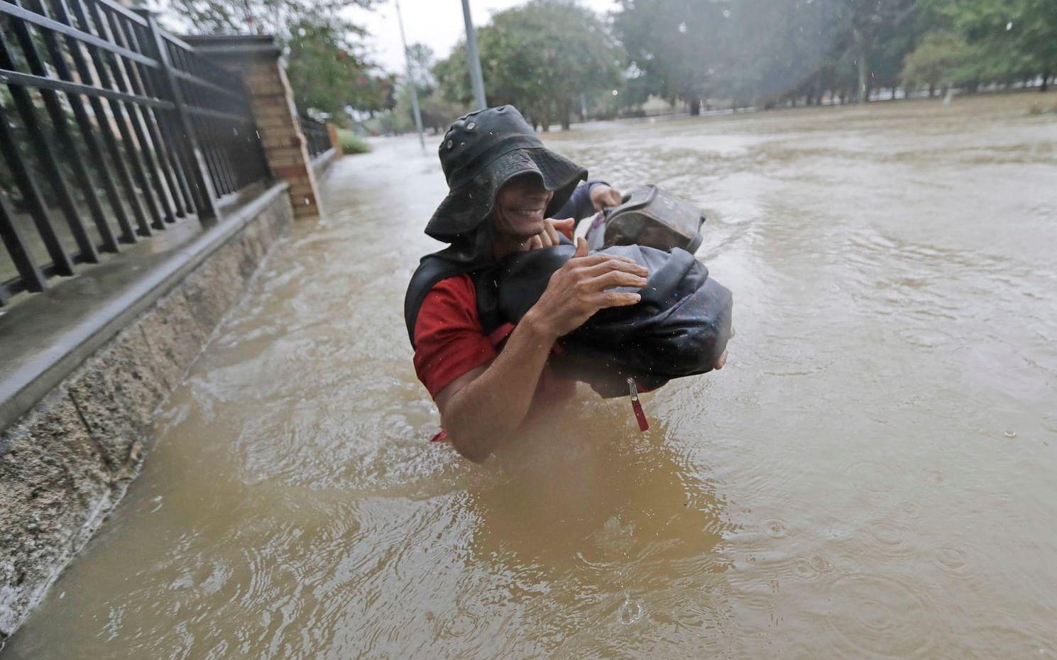 Boende i Houston vadar genom vattnet efter den tropiska stormens framfart. Bild: David j. Phillip/TT