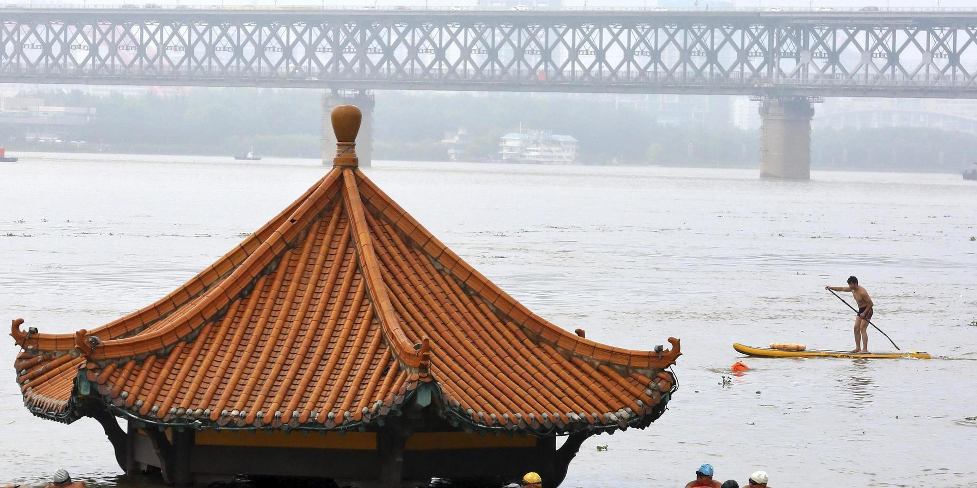 Invånare tar en simtur vid en paviljong som översvämmats vid Yangtzefloden i Wuhan i Hubeiprovinsen i förra veckan. 
