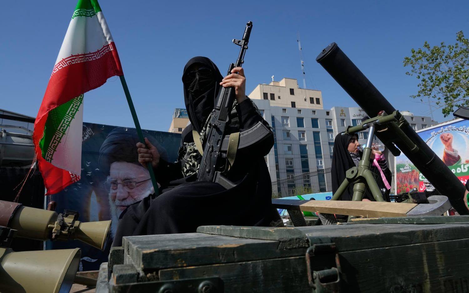 Medlemmar av Irans paramilitära Basij-styrkor visar upp sig med vapen i en statligt organiserad demonstration i Teheran på fredagen.