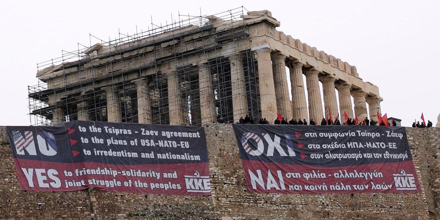 Medlemmar i Greklands kommunistiska parti har hängt upp en banderoll i protest mot namnöverenskommelsen, på Akropolis i Aten.