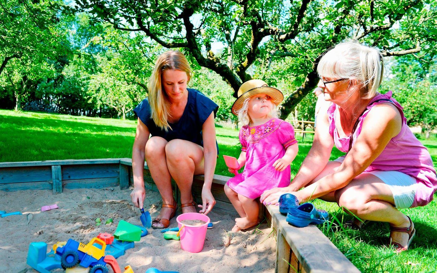 Astrid Larsson leker i sandlådan tillsammans med mamma Matilda Larsson och mormor Gunnel Larsson