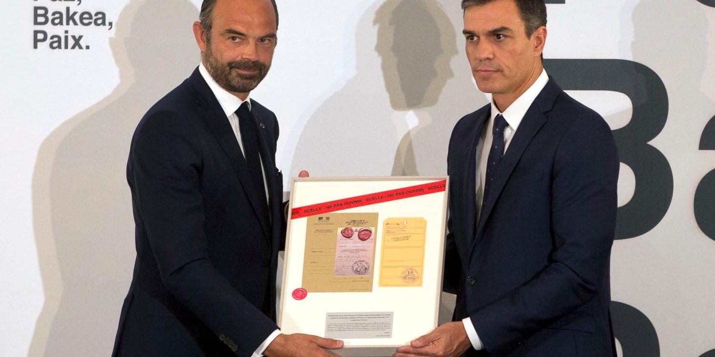 Den franske premiärministern Édouard Philippe och hans spanske kollega Pedro Sánchez håller i ett inramat dokument som berör kampen mot den baskiska separatistgerillan ETA.