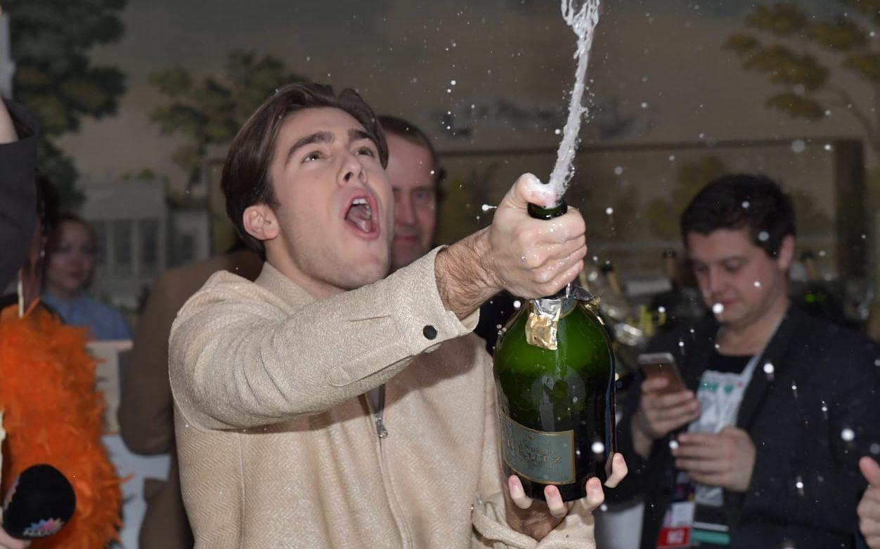 Den ena finalisten, Benjamin Ingrosso, har anlänt till festen. Han kör igång med att spruta bubbel. Foto: TT