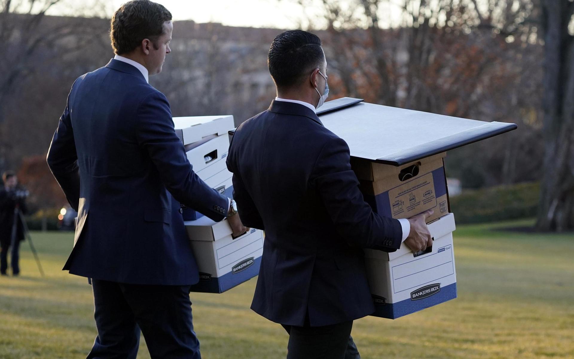 Personal i Vita huset bär ut lådor med dokument innan  Donald Trump lämnar presidentbostaden med helikoptern Marine One.
