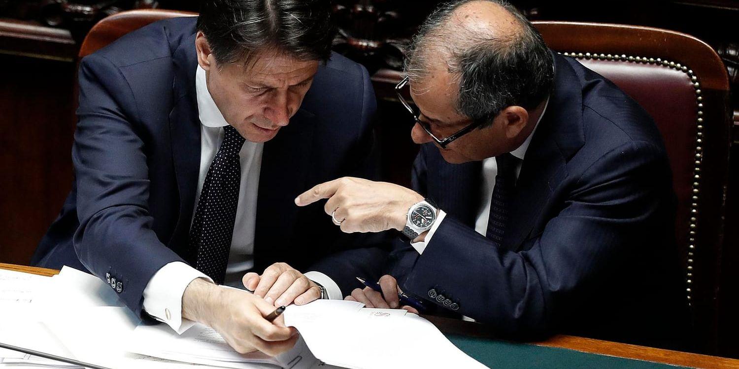 Italiens regeringskoalition leds av juristprofessorn Giuseppe Conte (till vänster), här i diskussion med finansministern och ekonomiprofessorn Giovanni Tria (till höger). Arkivbild.