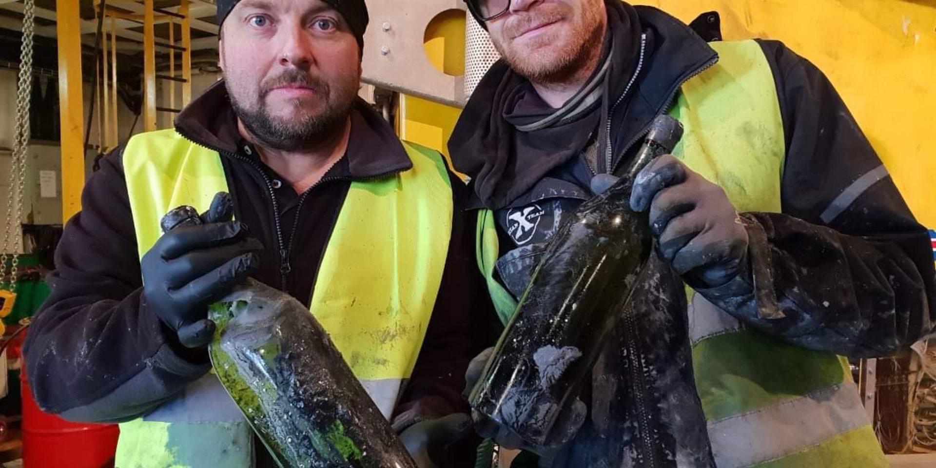 Dykaren Peter Lindberg (tv) och Floris Marsielle, specialist på undervattensteknik, med ett par av de 900 flaskor konjak och likör som nyligen bärgats från ett vrak i Ålands hav.