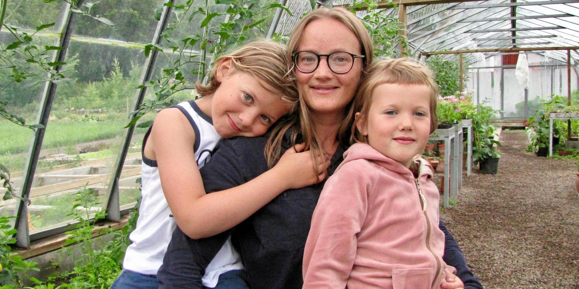 Janna Lundberg med barnen Arvid och Vera i föräldrarnas växthus i Källdalen. ”Det är en fantastisk plats att växa upp på och vi åker alltid hit med barnen på somrarna. Här kan de springa fritt och göra vad de vill”, säger Janna.
