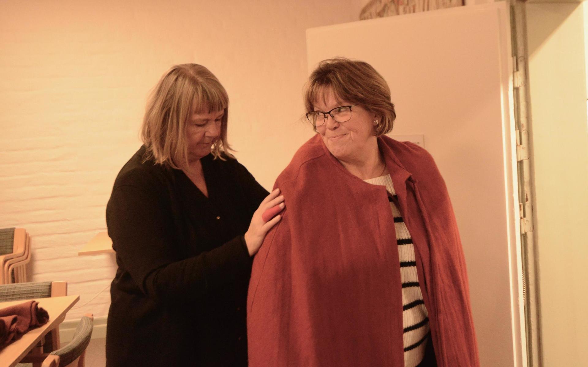 Harriet Andersson från Lions får hjälp av Christina Andersson-Wiking att få på sig sin medeltida mantel. 