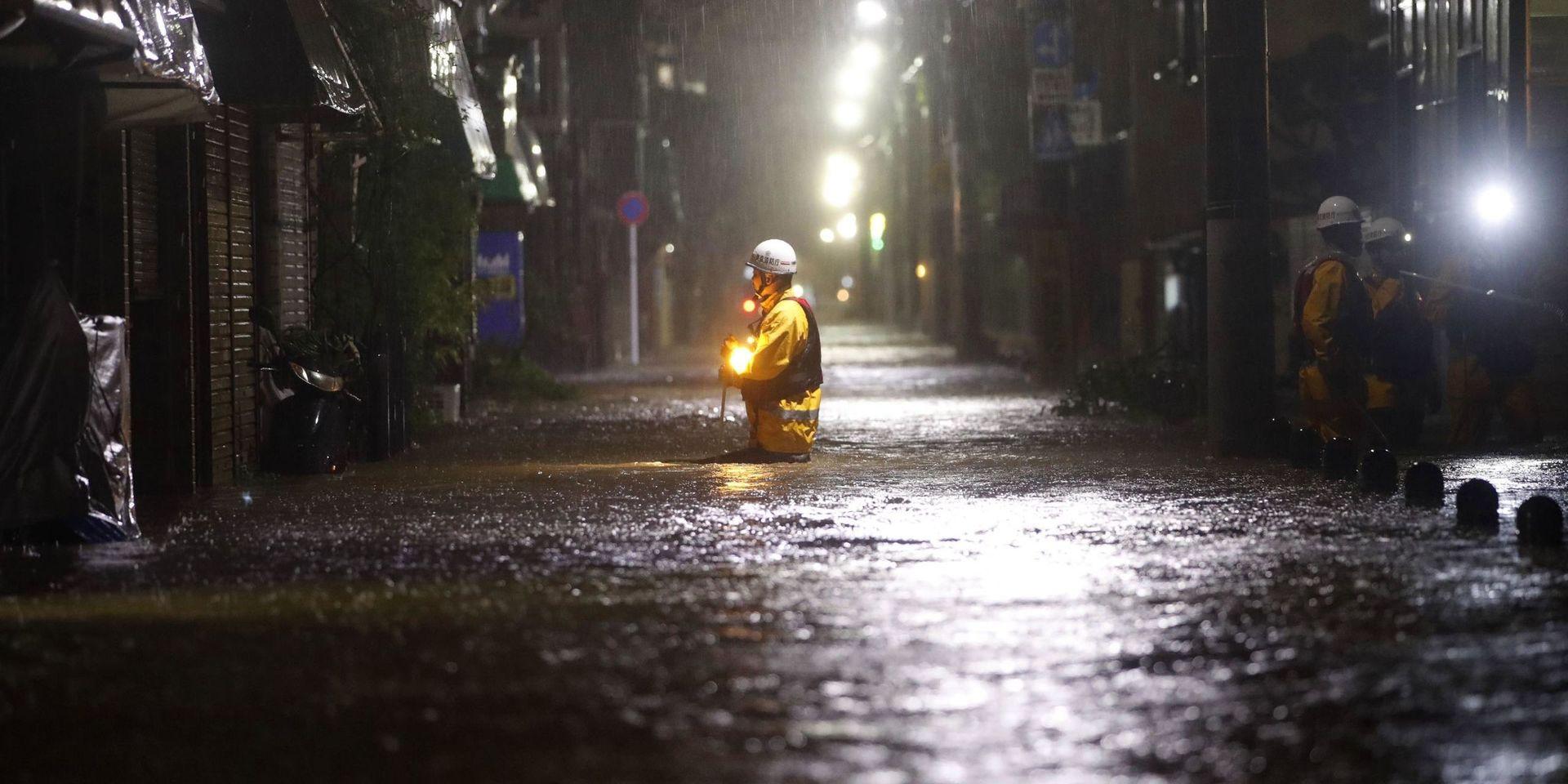 En brandman i en översvämmad gata i Tokyo. 