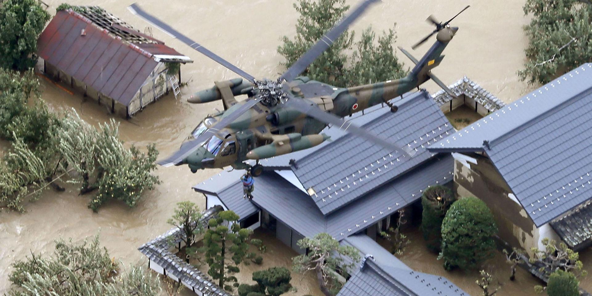 En invånare i Nagano räddas från ett översvämmat hus.