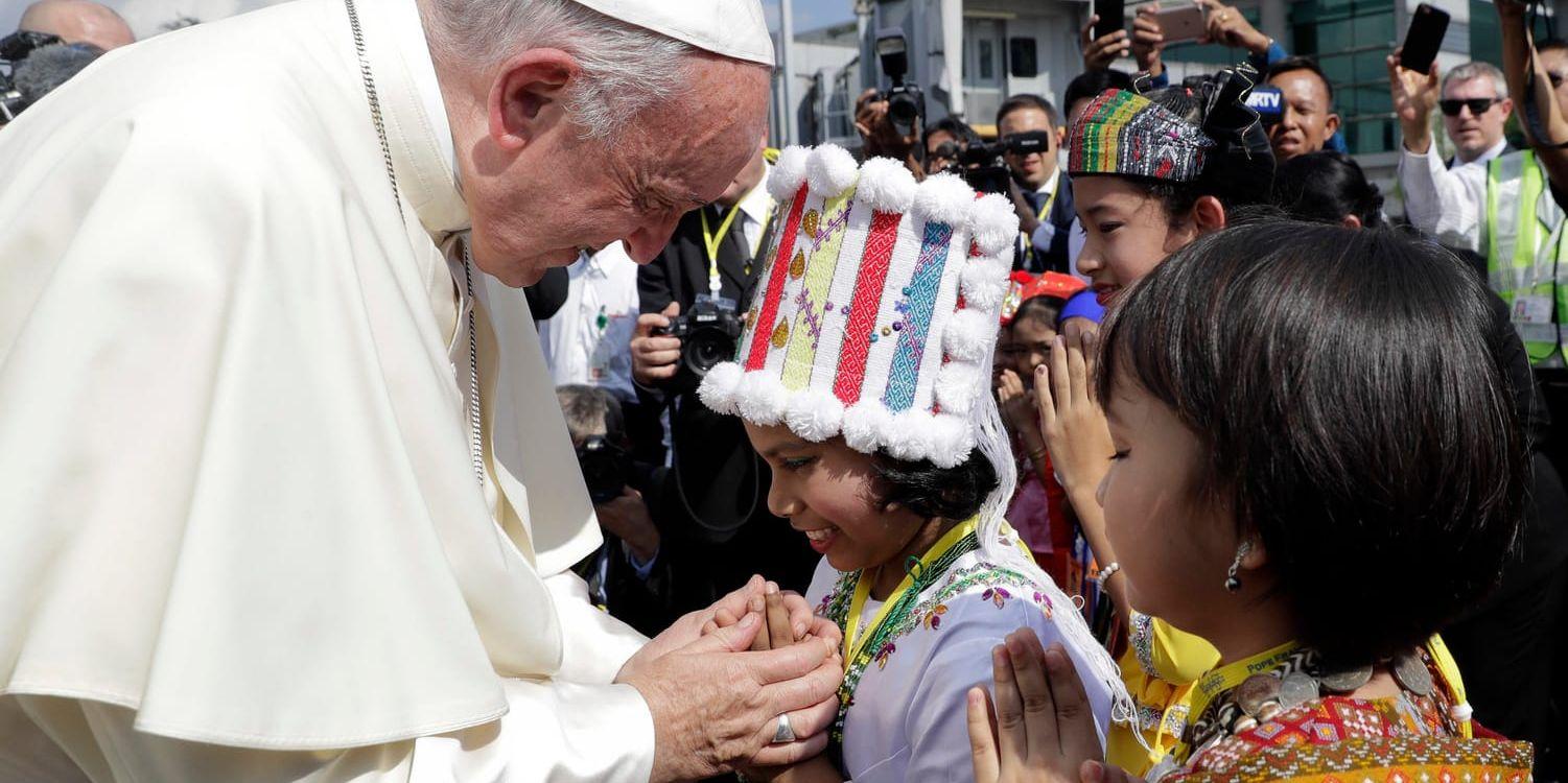 Påven hälsades välkommen av barn från olika minoritetsgrupper vid Rangoons flygplats.