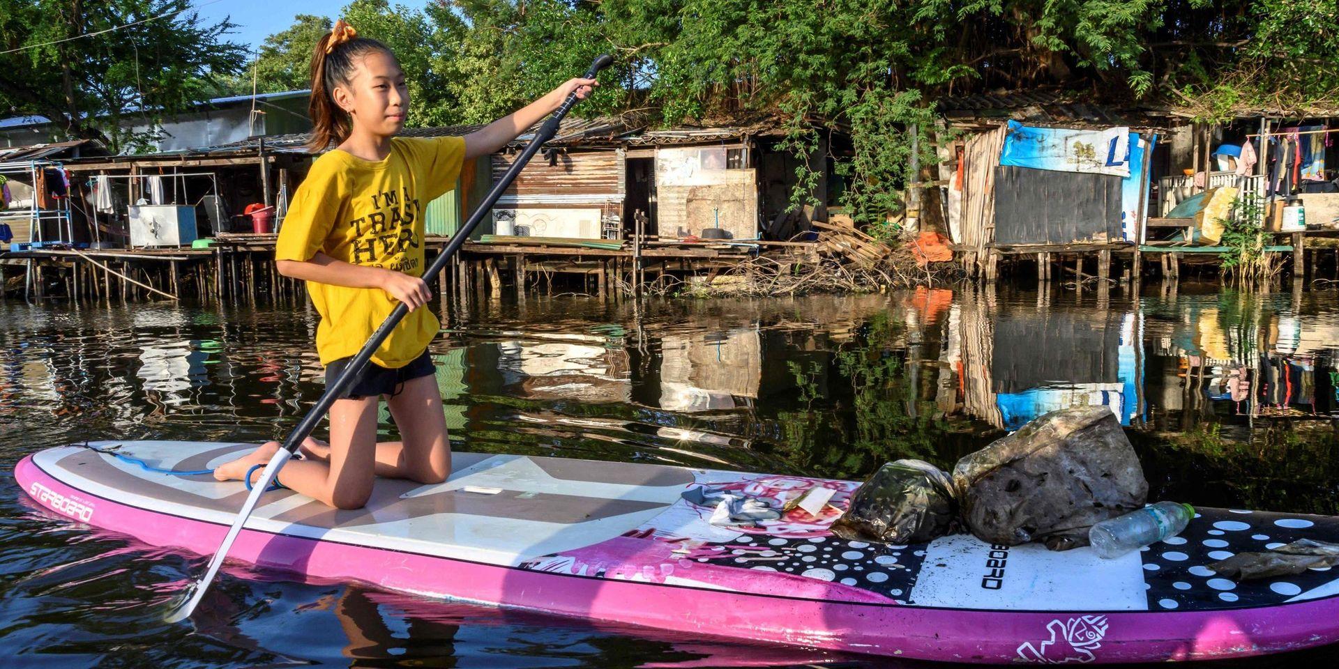Tolvåriga Ralyn Satidtanasarn paddlar i Bangkok för att fiska upp skräp. 